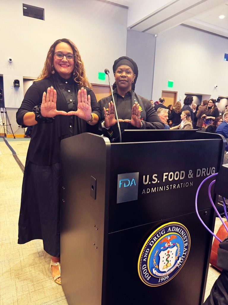 Dr. Lakisha and Dr. Denise Vidot at a U.S. Food and Drug Administration podium