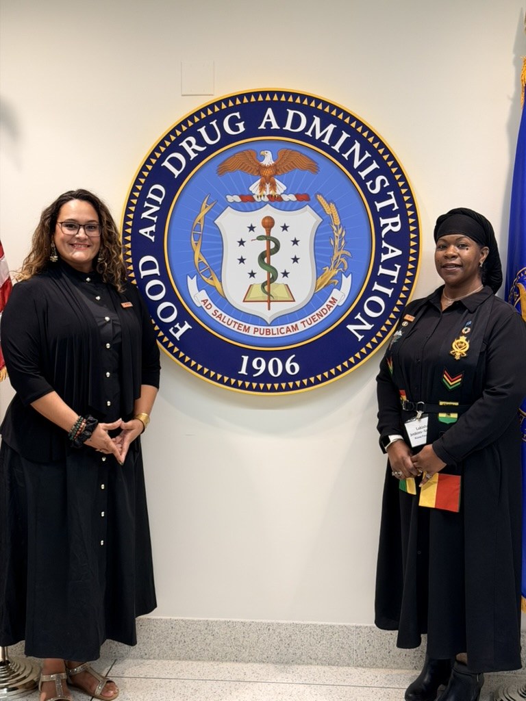 Dr. Lakisha and Dr. Denise Vidot beside the U.S. Food and Drug Administration seal
